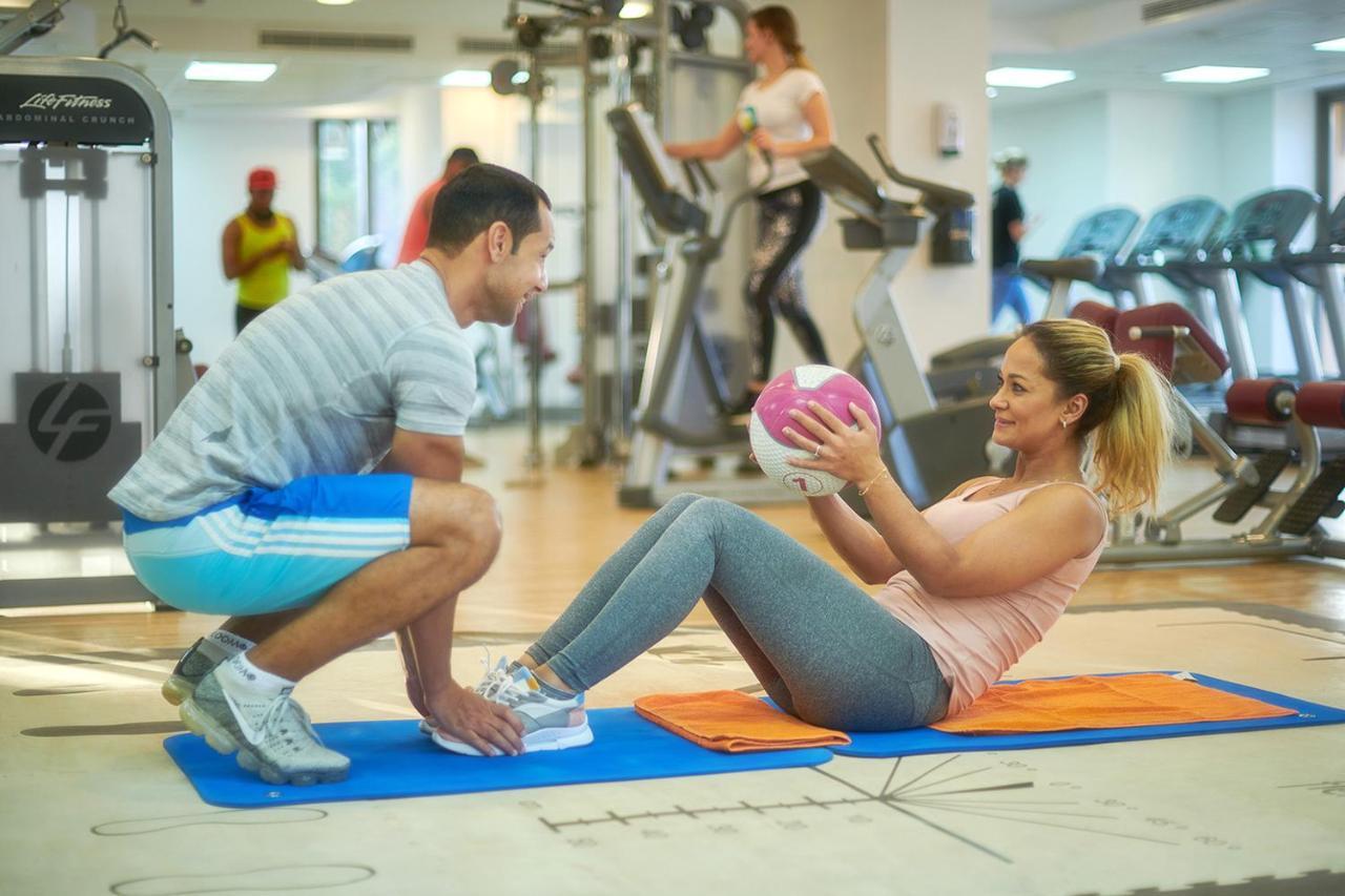 Bahi Ajman Palace Hotel Zewnętrze zdjęcie Personal trainer assisting a woman with sit-ups